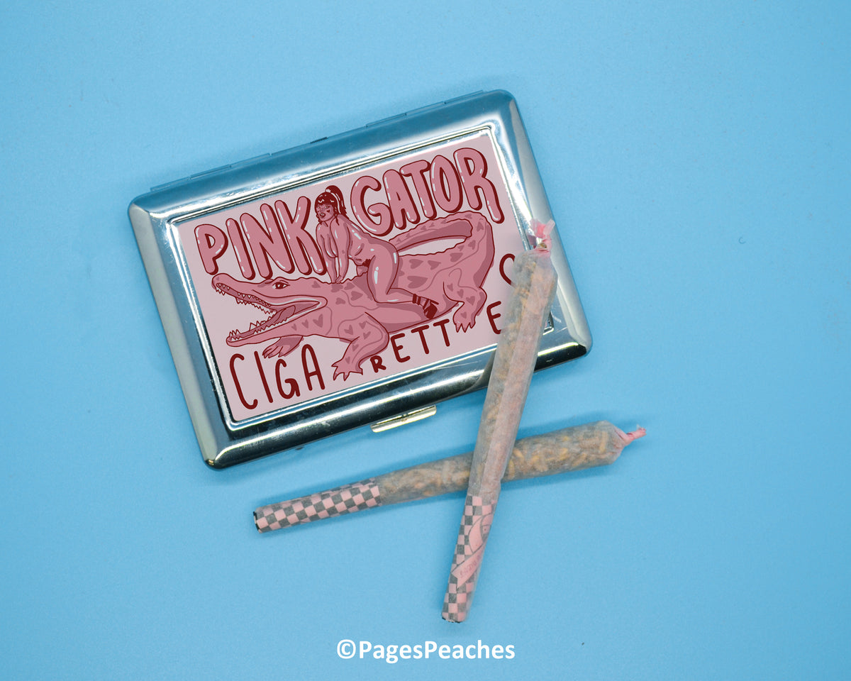 a cigarette case sitting next to a pair of pinky gator cigarettes