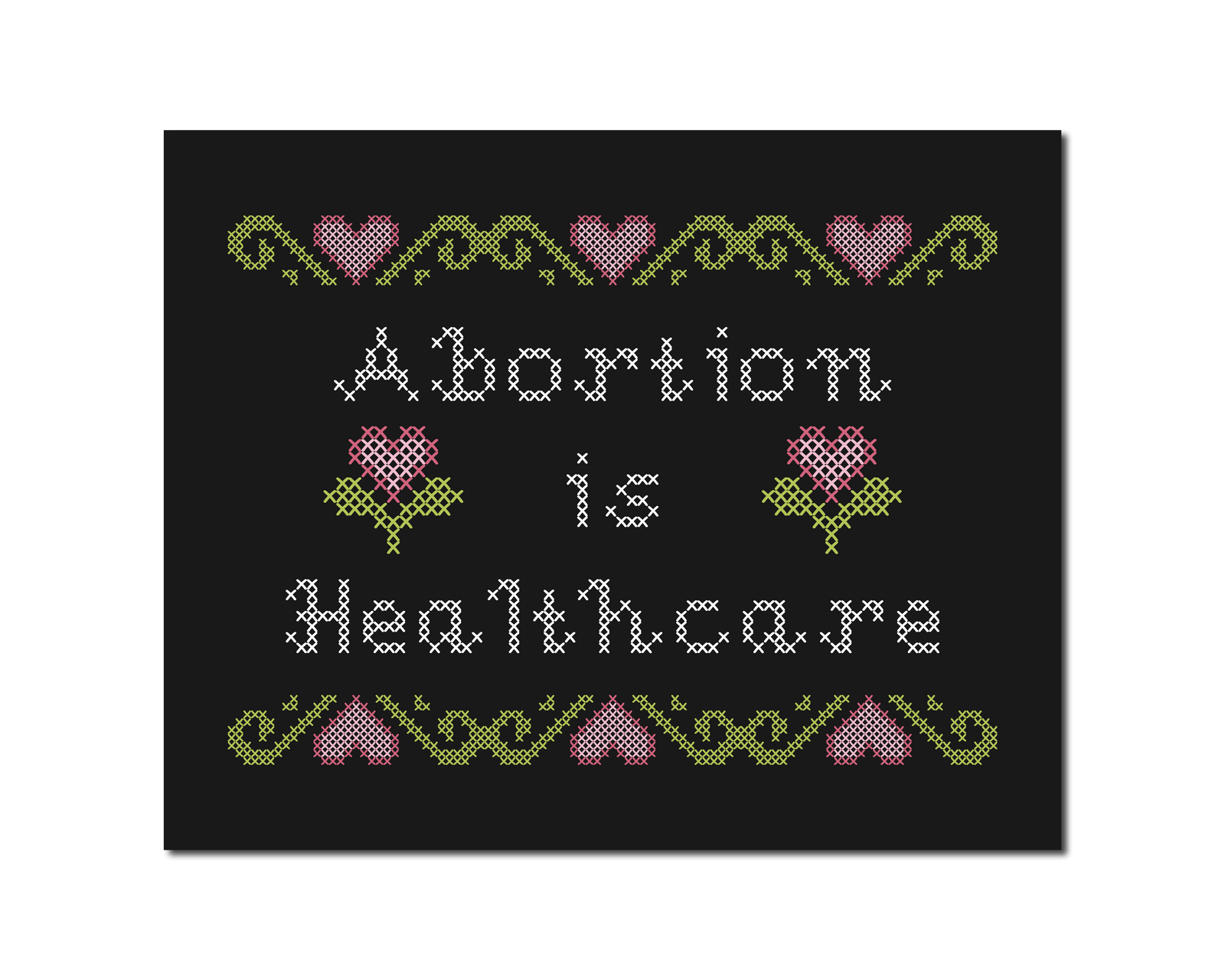 Cross-stitch style print with white text reading “Abortion Is Healthcare”