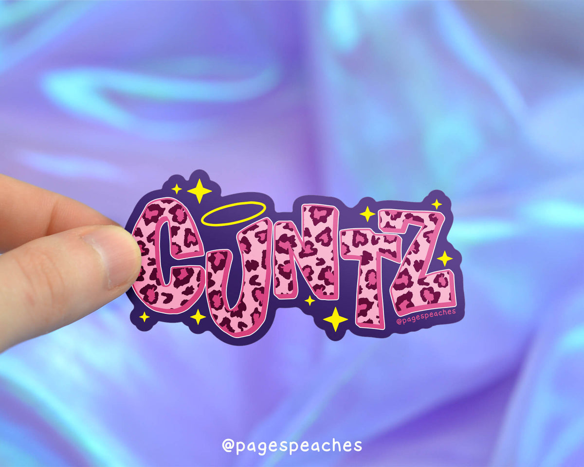 Sticker with &#39;CUNTZ&#39; design held by a hand against a colorful background