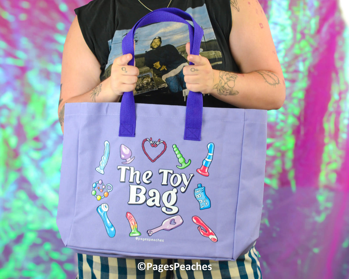Person holding a purple tote bag with colorful illustrations and text against a multicolored background.