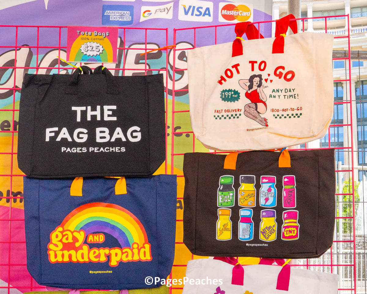 a collection of colorful tote bags with various designs and text, including a black bag with &quot;THE FAG BAG&quot; printed on it, a white bag with &quot;HOT TO GO&quot; and &quot;ANY DAY ANY TIME&quot; printed on it, and a blue bag with a rainbow graphic and the text &quot;Gay and Underpaid&quot; printed on it.