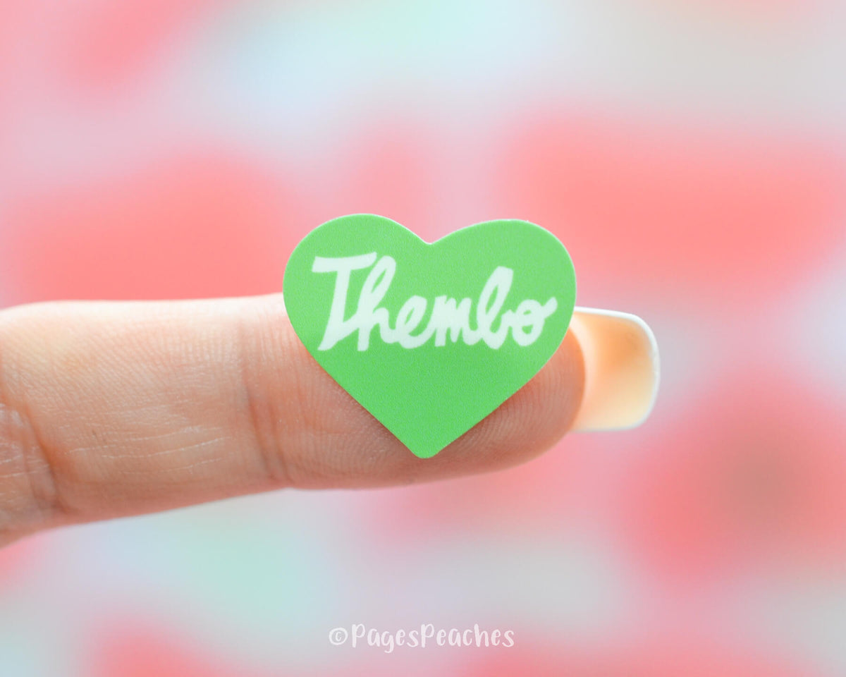 Small green heart thembo sticker stuck to a finger