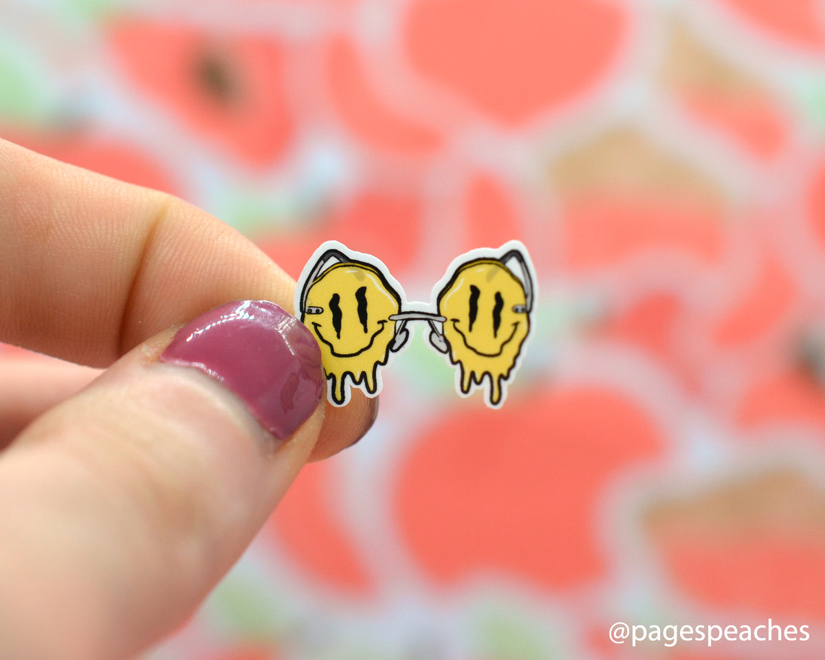 Small Smiley Face Glasses Sticker Stuck to a finger