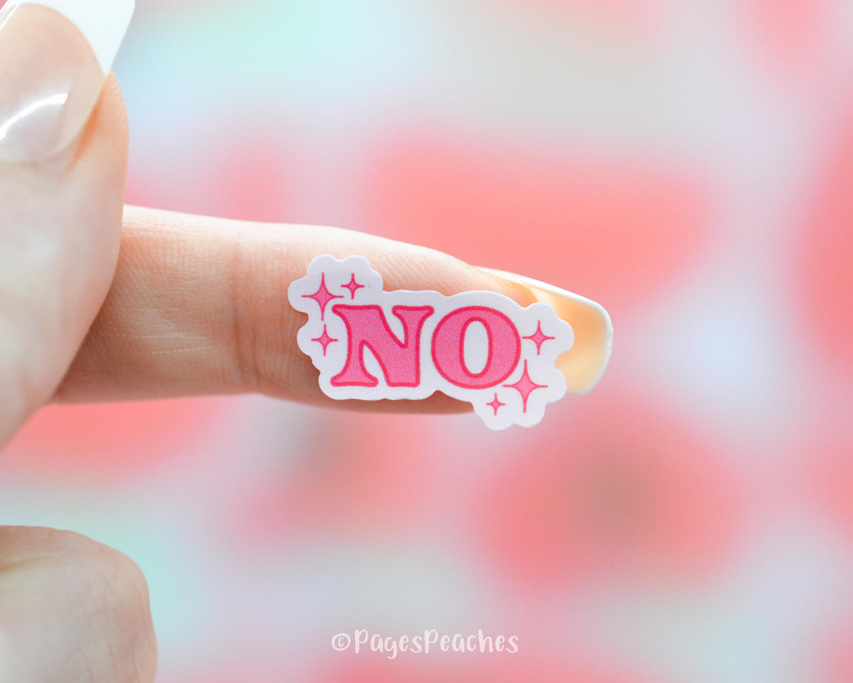 Small Pink Sticker that No with sparkles stuck to a finger