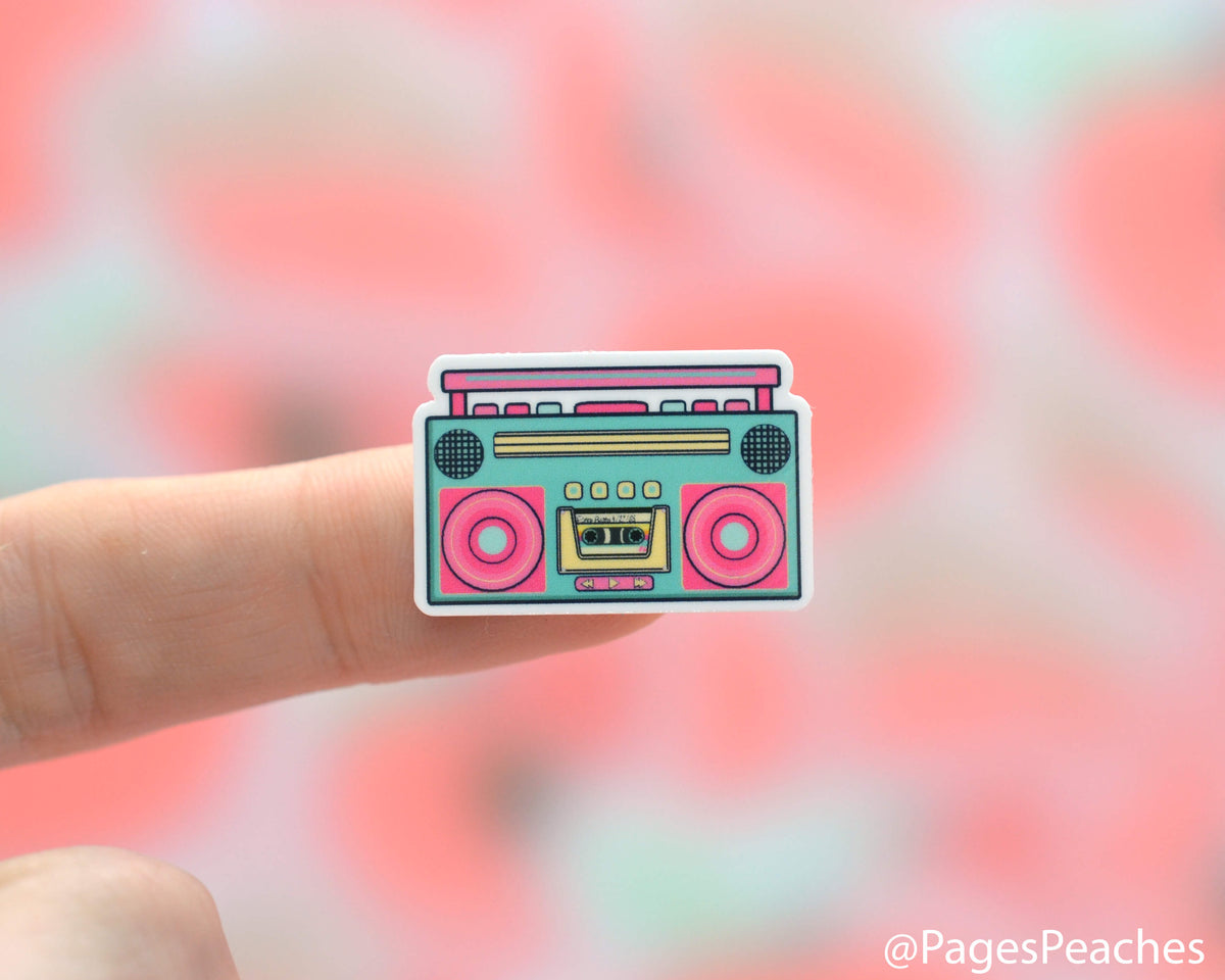 Small sticker of an old school boom box stuck to a finger