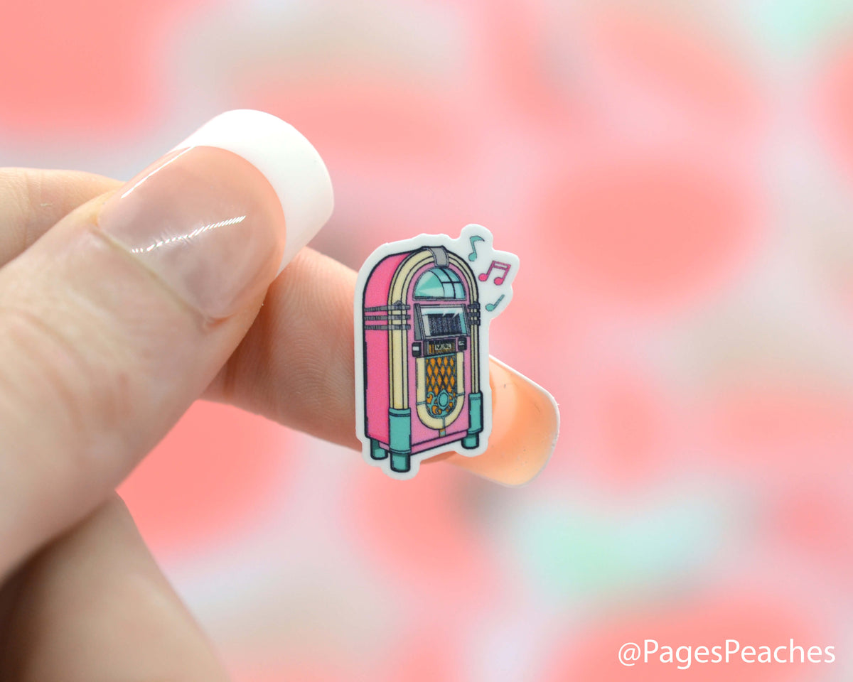 Small Sticker of an 80s jukebox stuck to a finger