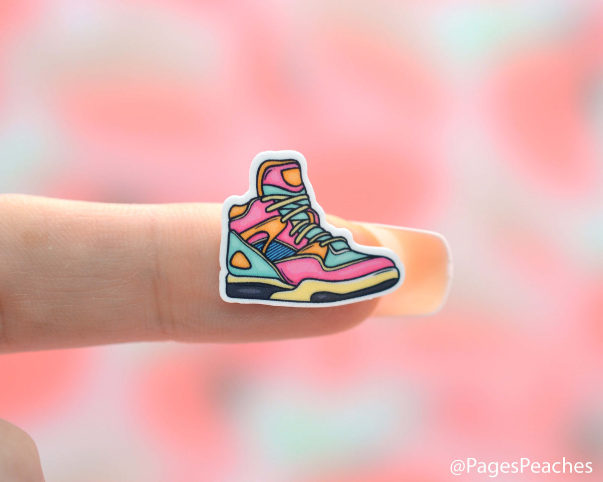 Small Sticker of an 80s Shoe Stuck to a finger