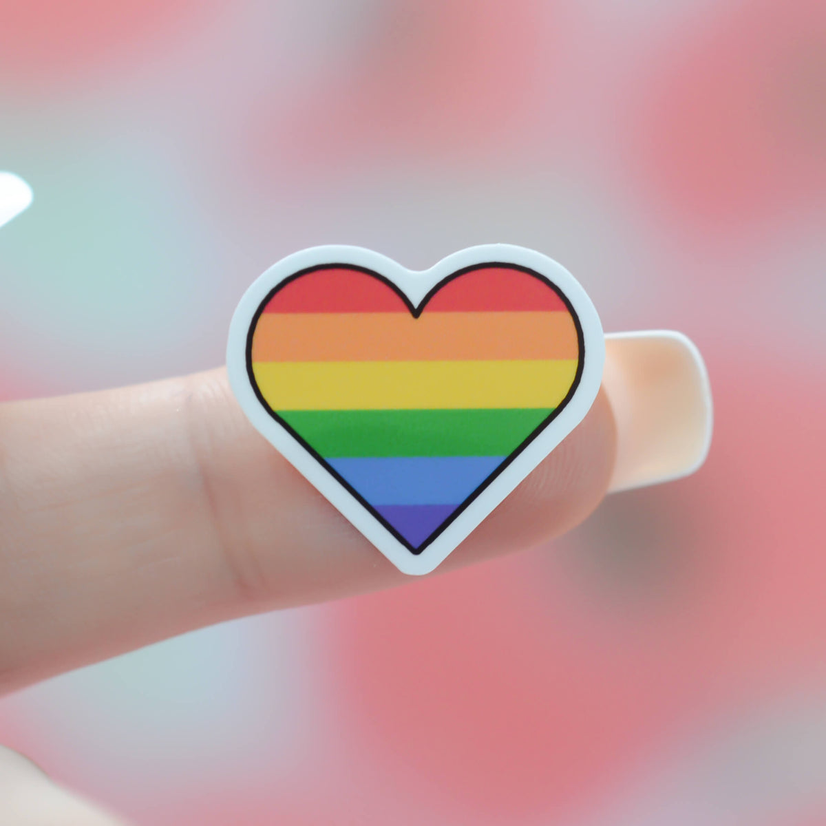 Small Heart shaped rainbow flag stuck to a finger
