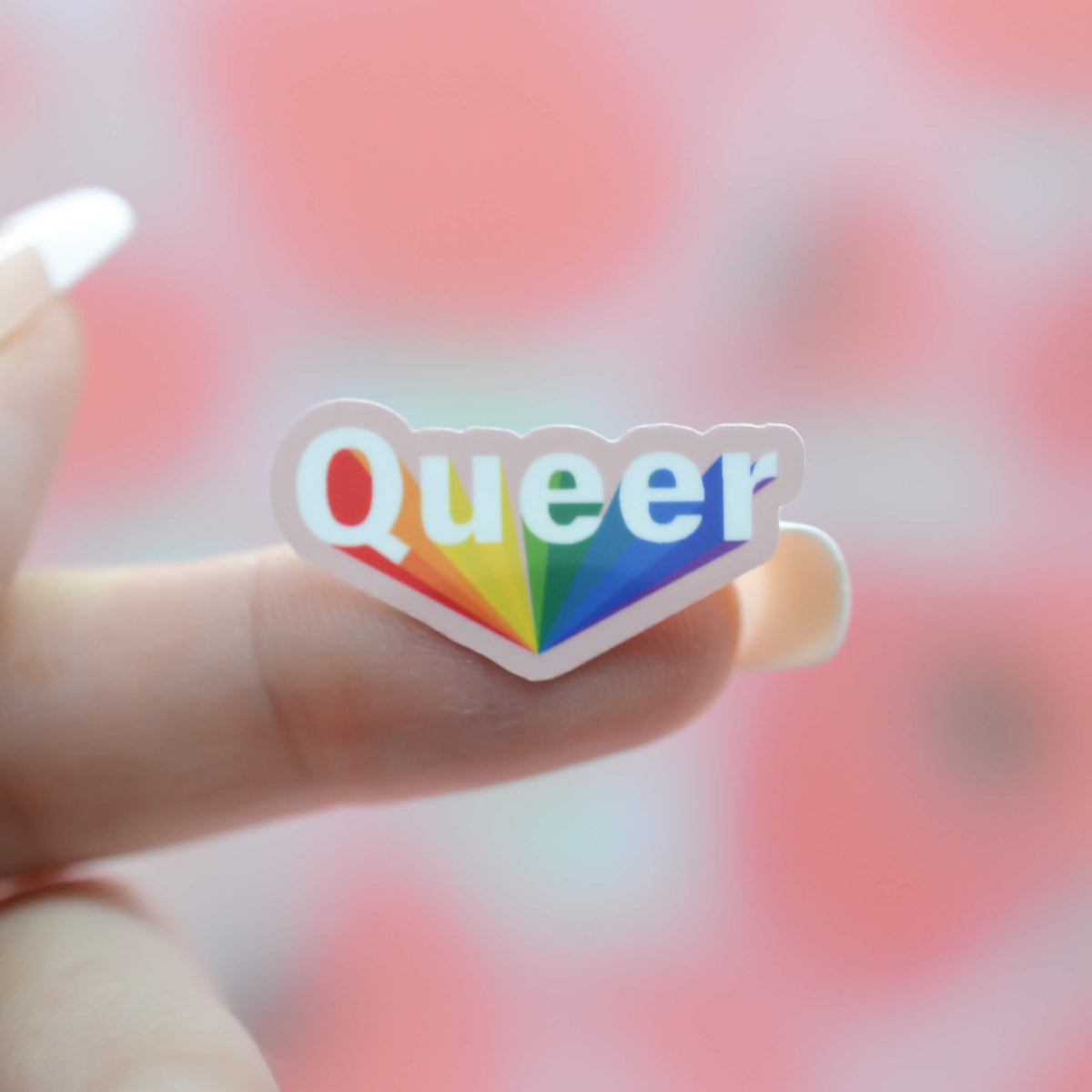 Small Queer Sticker That is stuck to a finger