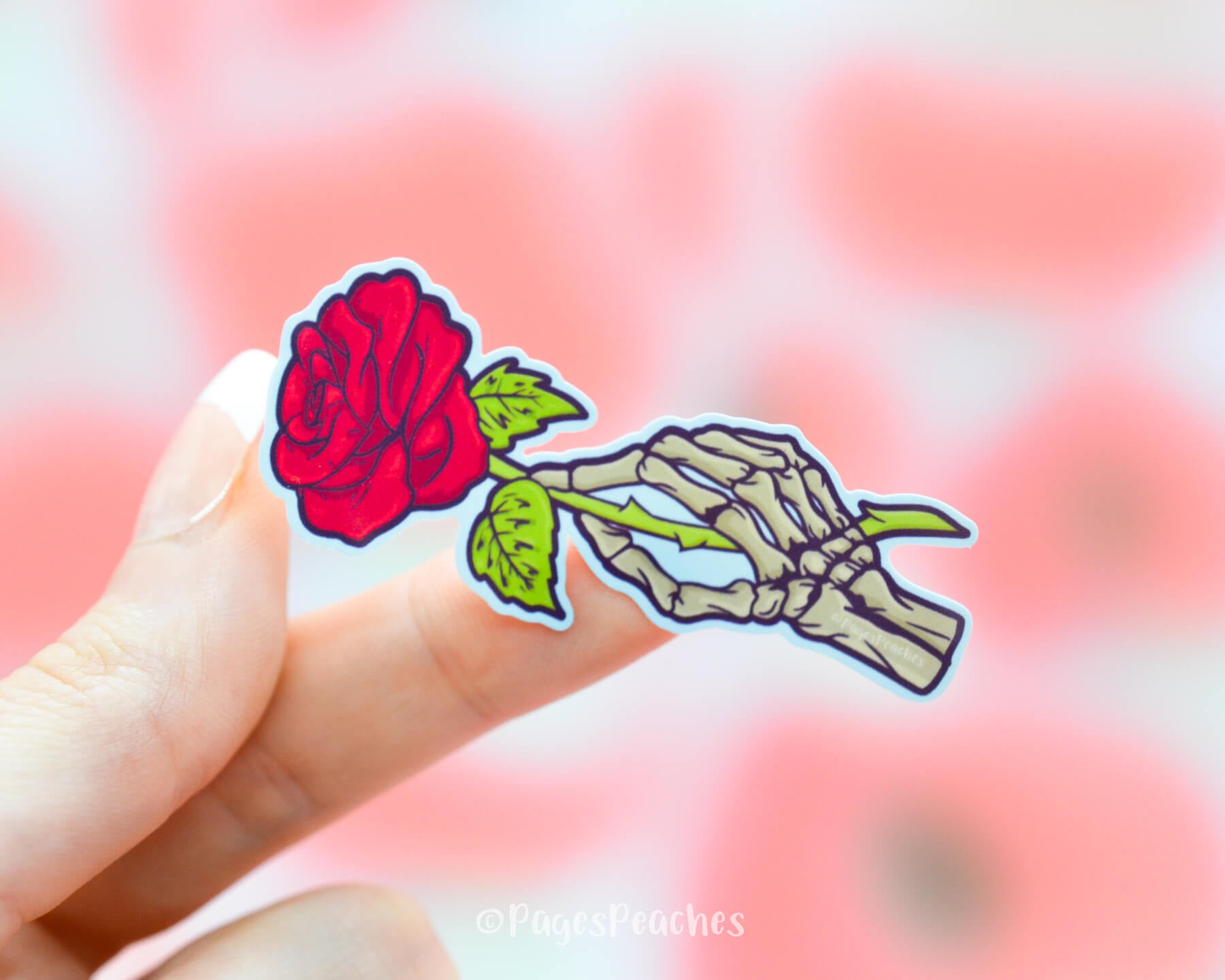 Sticker of a skeleton hand holding a bright red rose