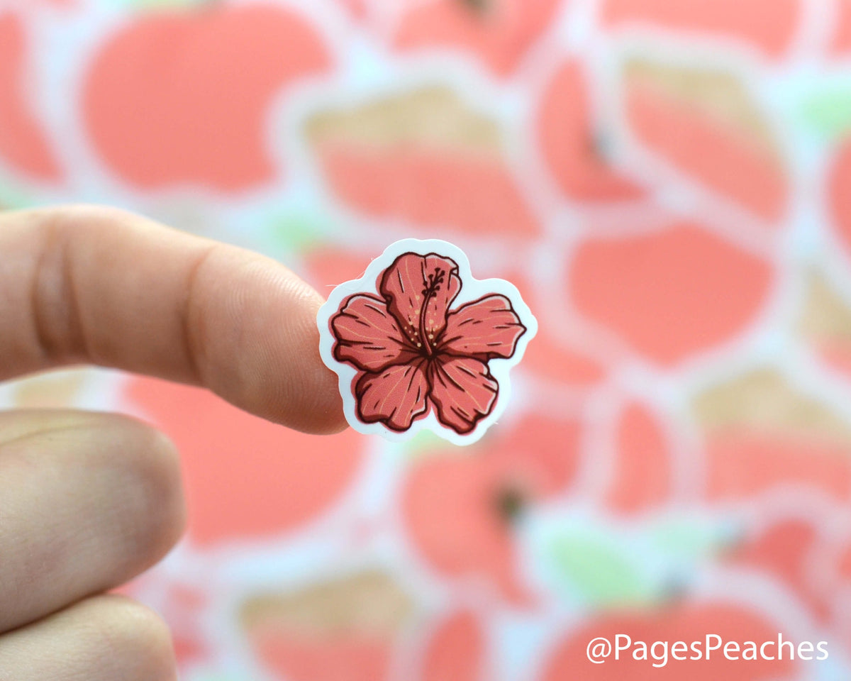 Small Sticker of a hibiscus flower stuck to a finger
