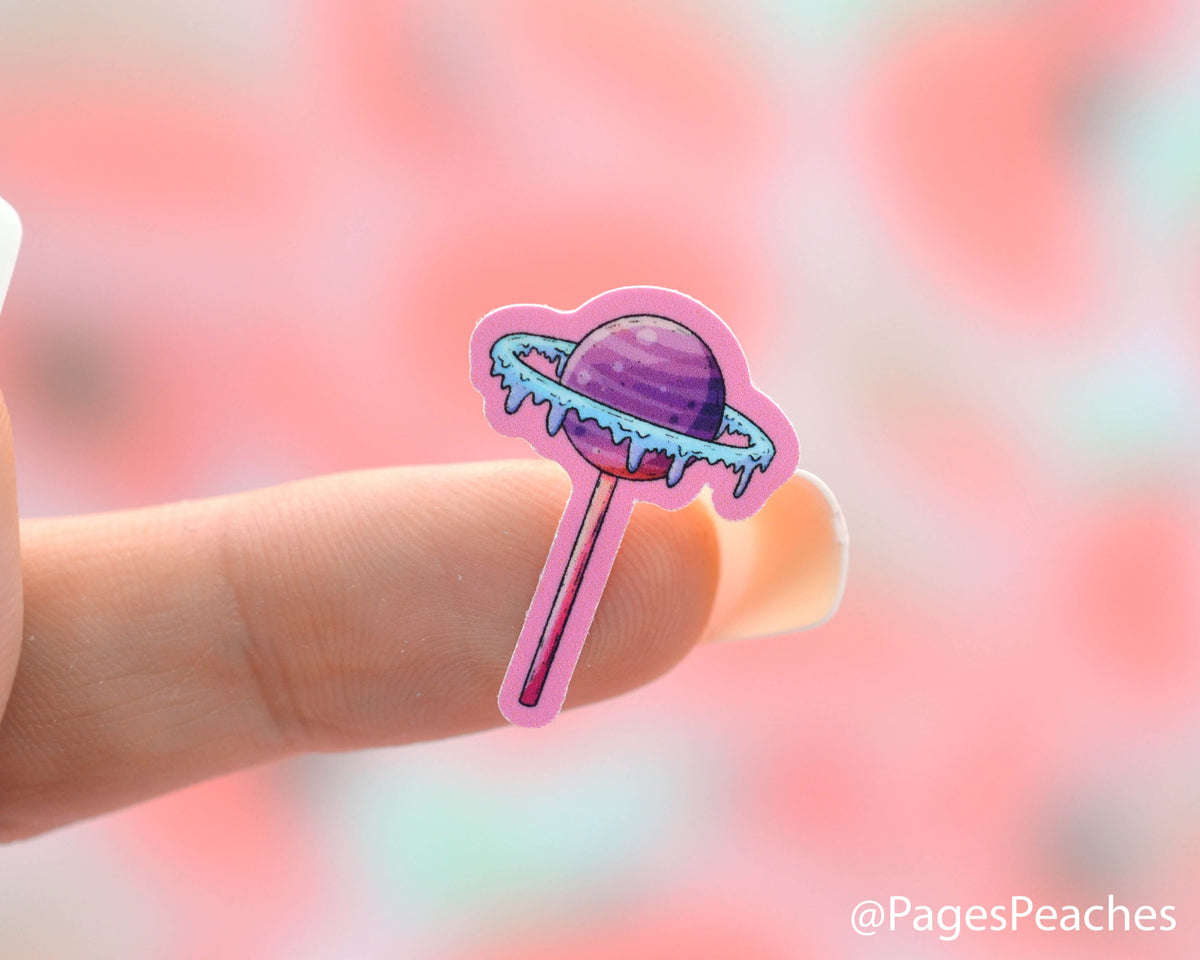 Small Sticker of a Planet Lollipop Stuck to a finger