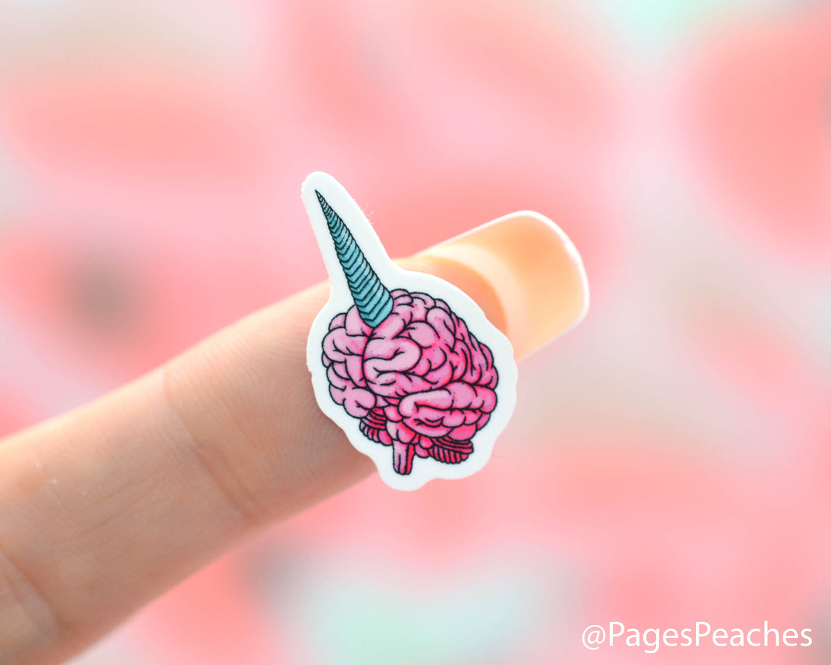 Small unicorn brain sticker stuck to a finger