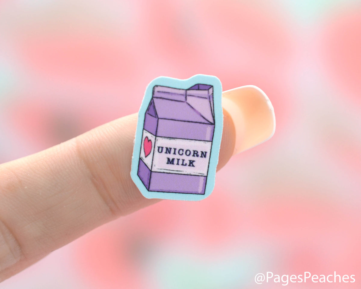 Small Unicorn Milk Carton Sticker stuck to a finger
